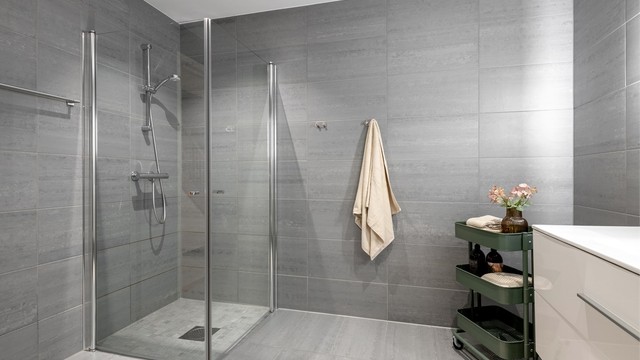 Badet har dusjhjørne med innfellbare glassdører.