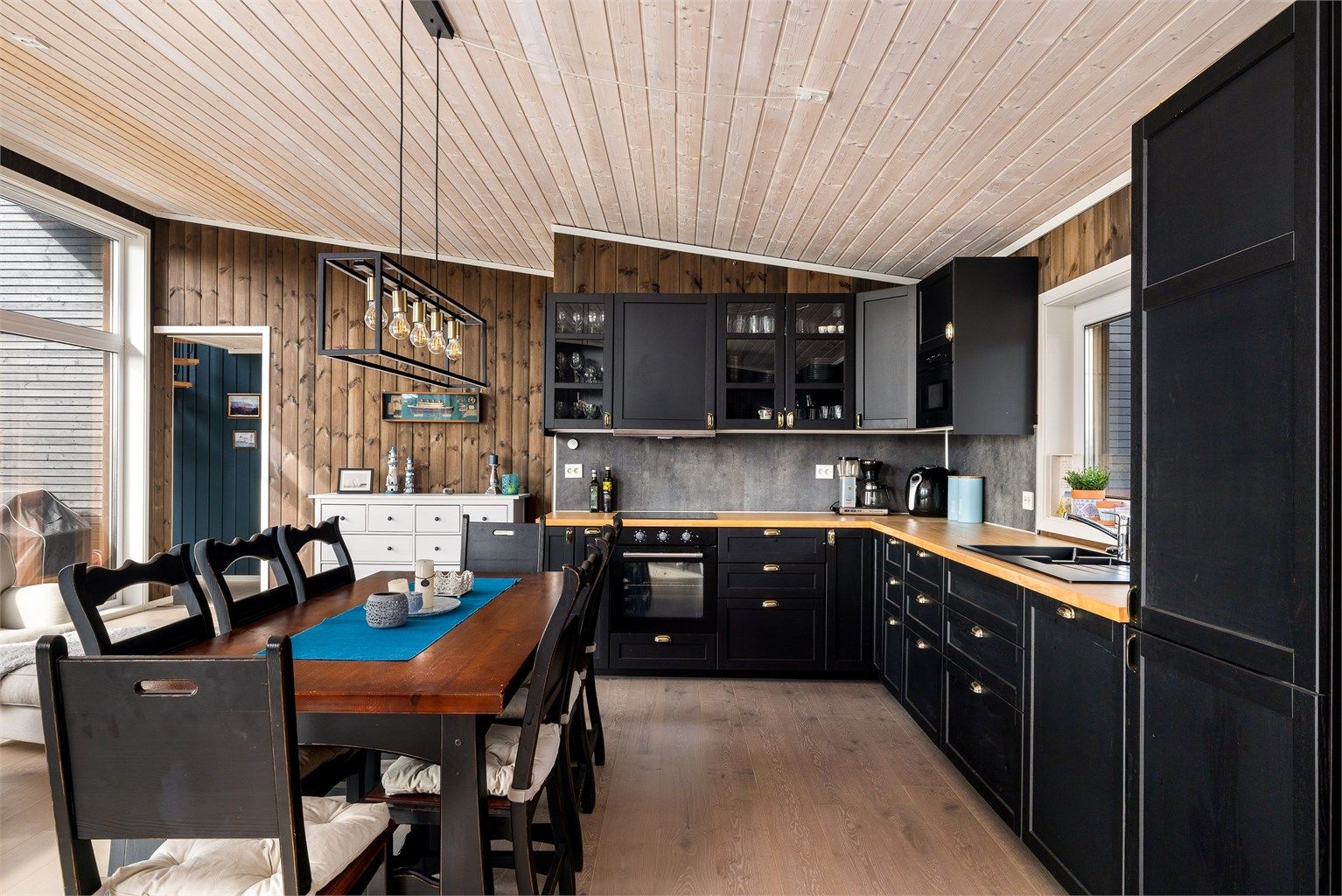 Kjøkkeninnredningen har en arbeidsvennlig L form og benkeplate i heltre eik. Plater med glatt overflate mellom benken og overskap er praktisk og letter renholdet.