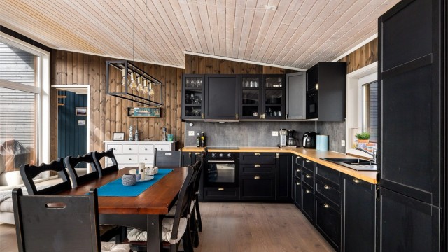 Kjøkkeninnredningen har en arbeidsvennlig L form og benkeplate i heltre eik. Plater med glatt overflate mellom benken og overskap er praktisk og letter renholdet.