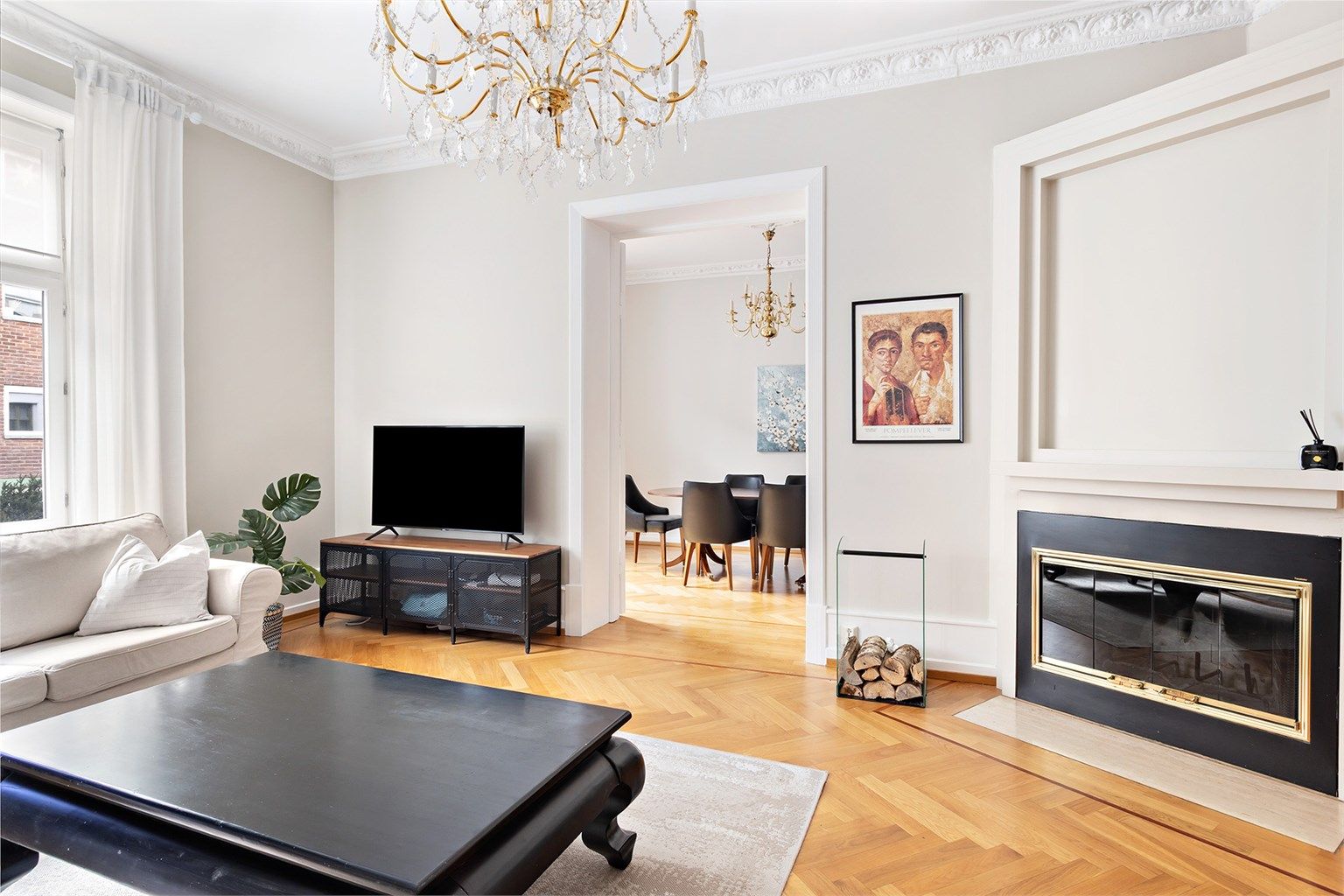 Romslig og møblert stue med peis, samt store vinduer som slipper inn masse naturlig lys. 