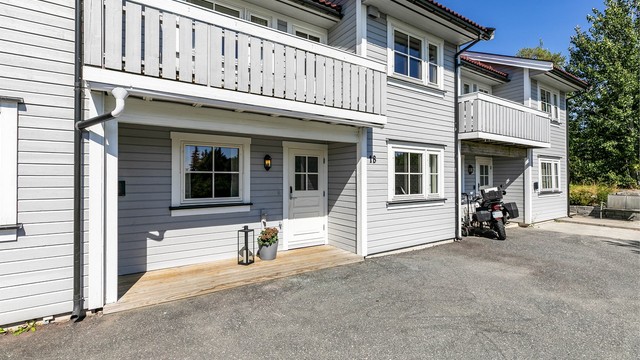 Lader til EL-bil er montert på husveggen ved inngangspartiet.