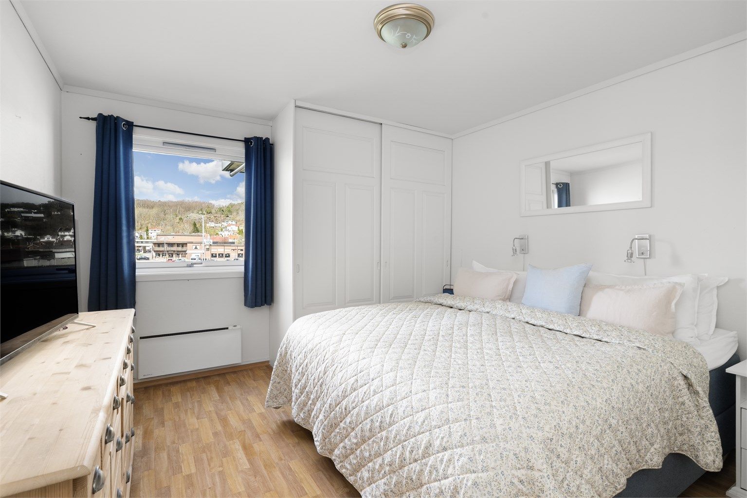 Hovedsoverommet har plassbygget garderobeskap med skyvedører og utsikt mot havnen.
