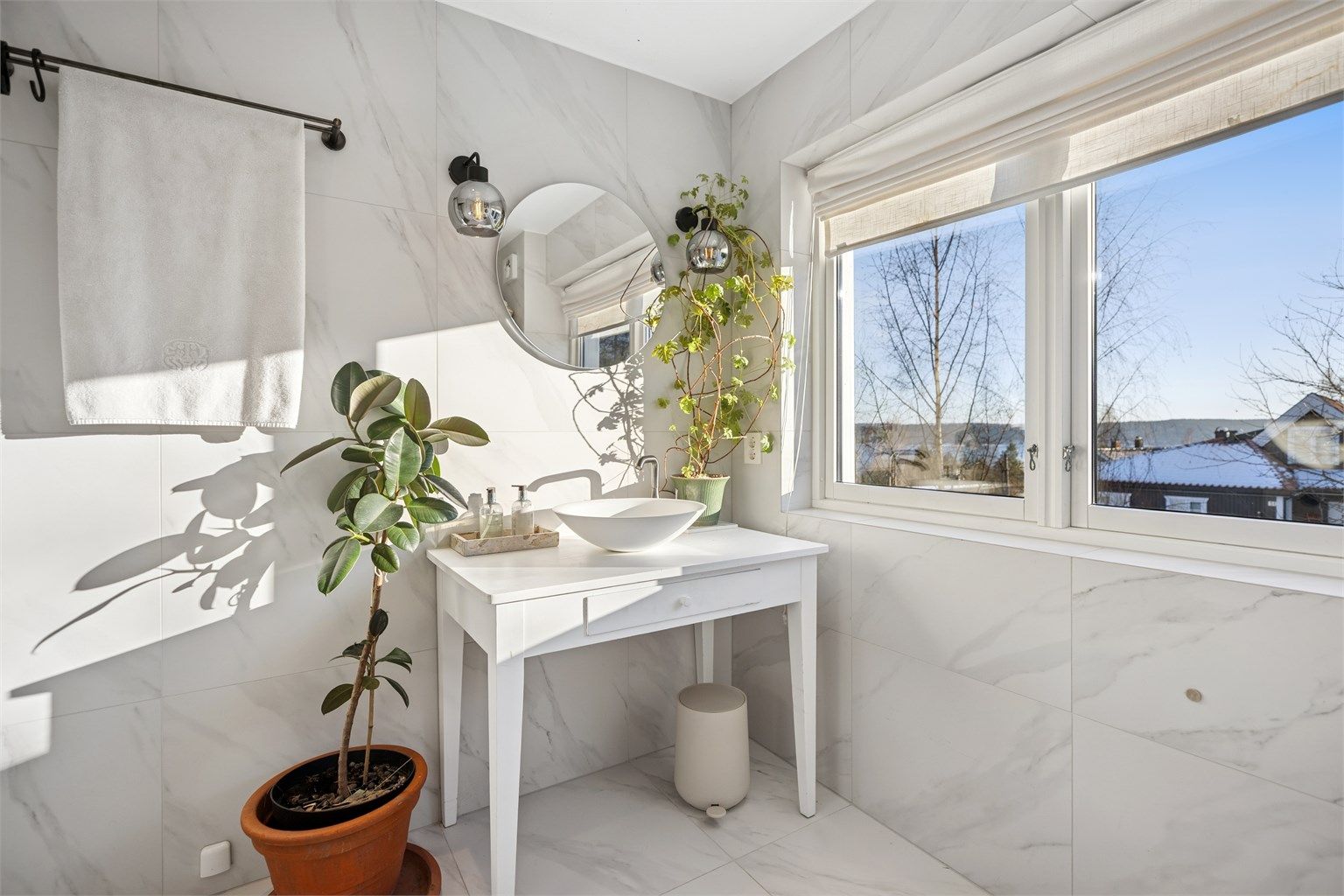 Badet er innredet med kombinert veggmontert og gulvstående innredning med ovenpåliggende servant og ettgreps armatur og speil med integrert belysning.