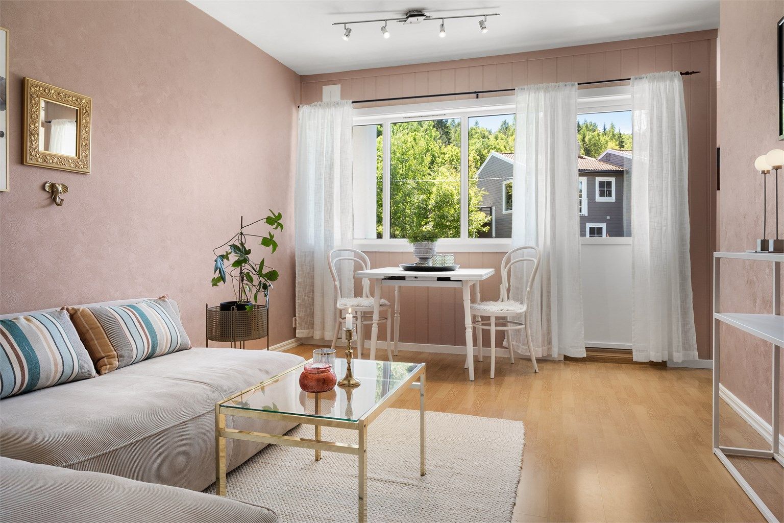 Lys stue med plass til både sofaområde og spiseplass.