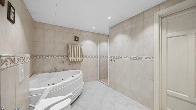 Badet er utstyrt med både dusjnisje med glassdør og badekar.