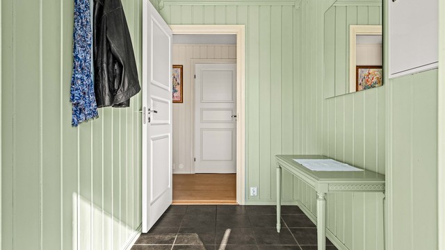 Entréen har flislagt gulv og gir direkte tilgang til boligens oppholdsrom. Sikringsskapet er plassert her.