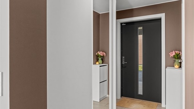 God plass til oppbevaring av yttertøy i en romslig skyvedørsgarderobe.
