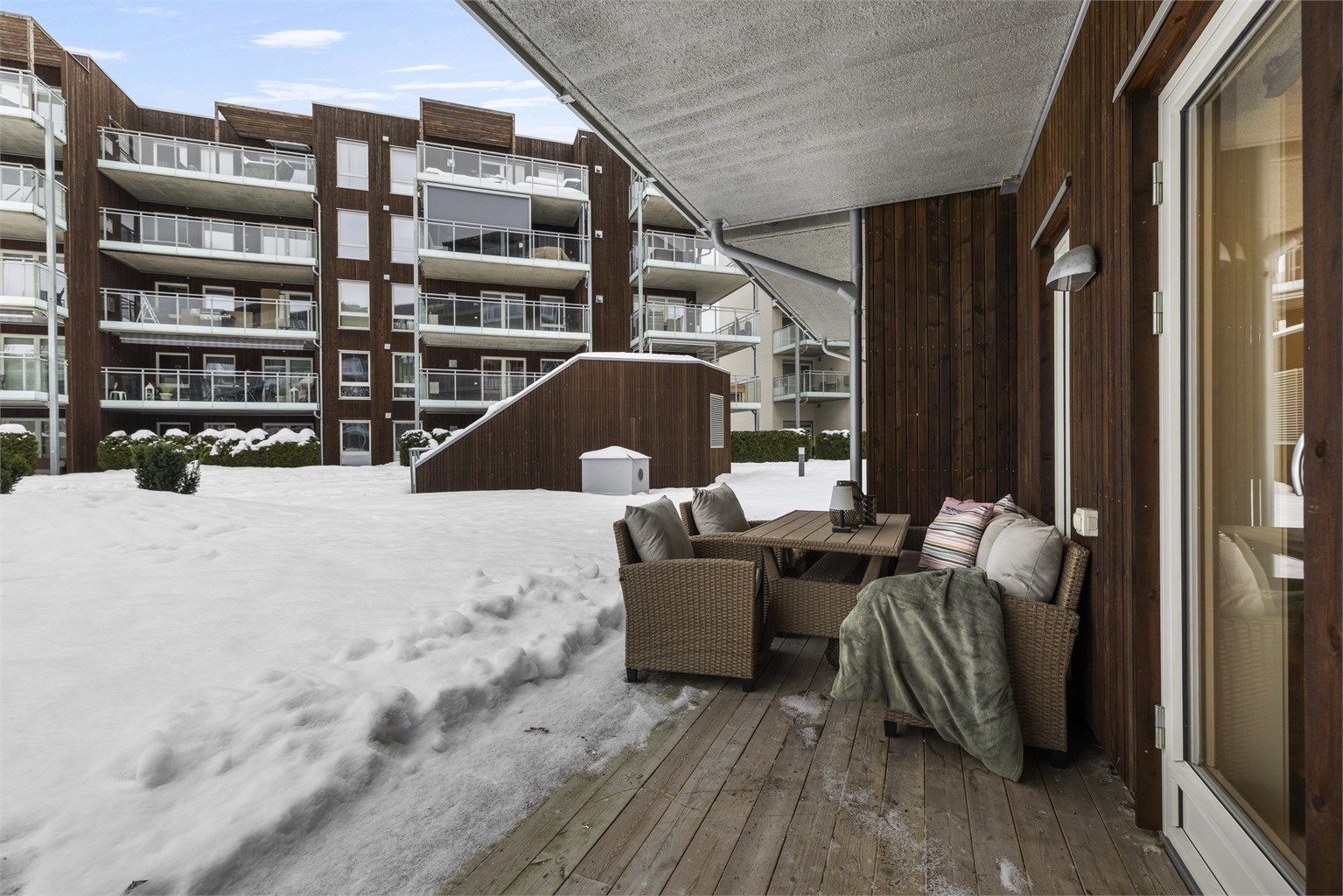 Markterrassen er et hyggelig uterom med plass til sittegruppe. Gulvet er lagt med terrassebord, og levegger i trepanel gir en lun følelse.
