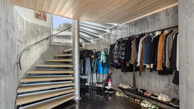 Inngangspartiet i kjelleren har en tøff kombinasjon av fliser på gulv og vegger i ubehandlet betong.