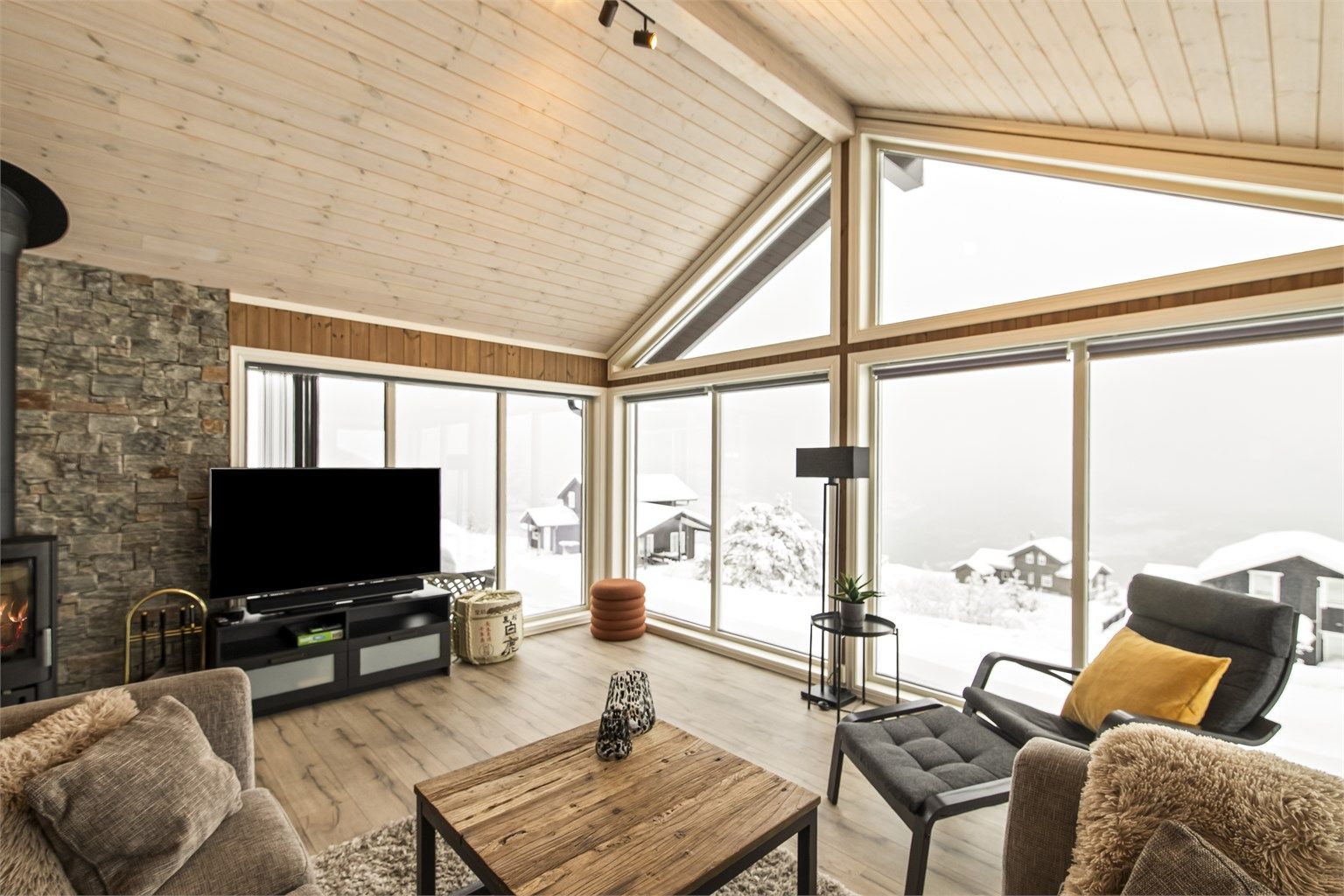 Stuen er lys og koselig med peisovn for kjøligere sesonger