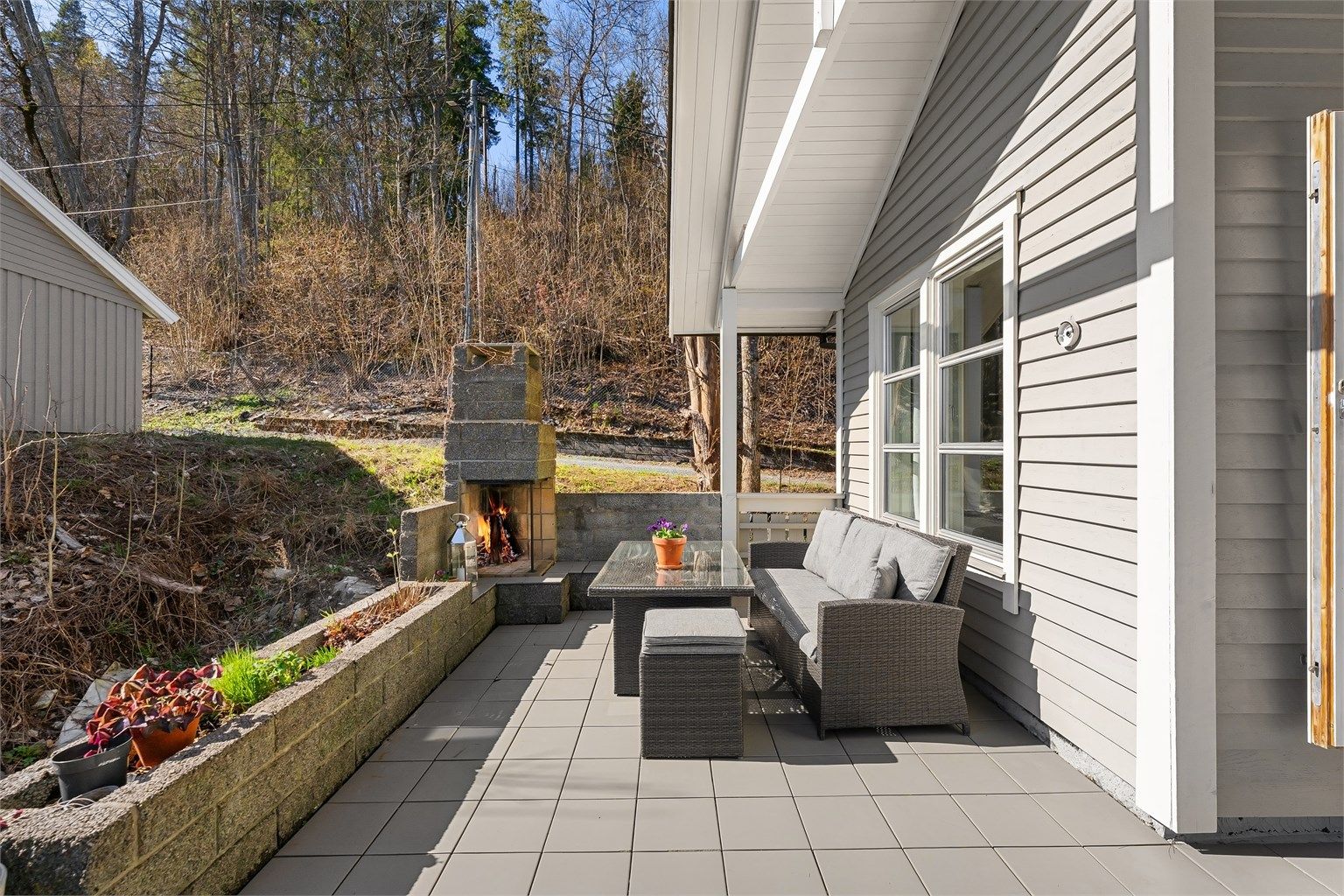 Uteplassen er delvis takoverbygget, noe som gir ly for vær og vind.