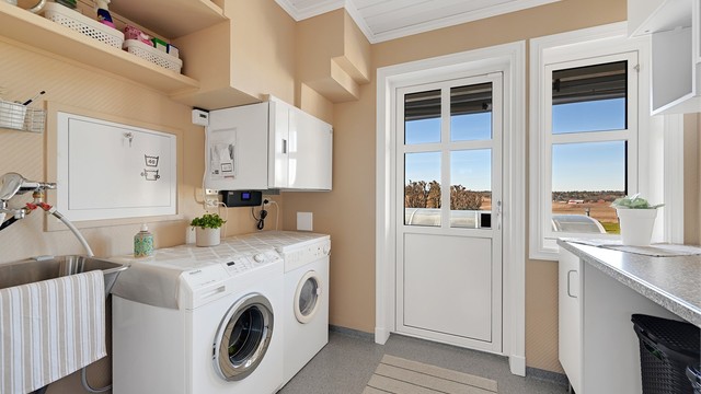 Vaskerommet har egen inngang, opplegg for vaskemaskin og tørketrommel, og huser det balanserte ventilasjonsaggregatet fra 2022.