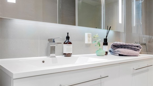 Delikat, flislagt bad fra byggeåret med innredning fra Bano Prefab. Det er gulvvarme for økt komfort.