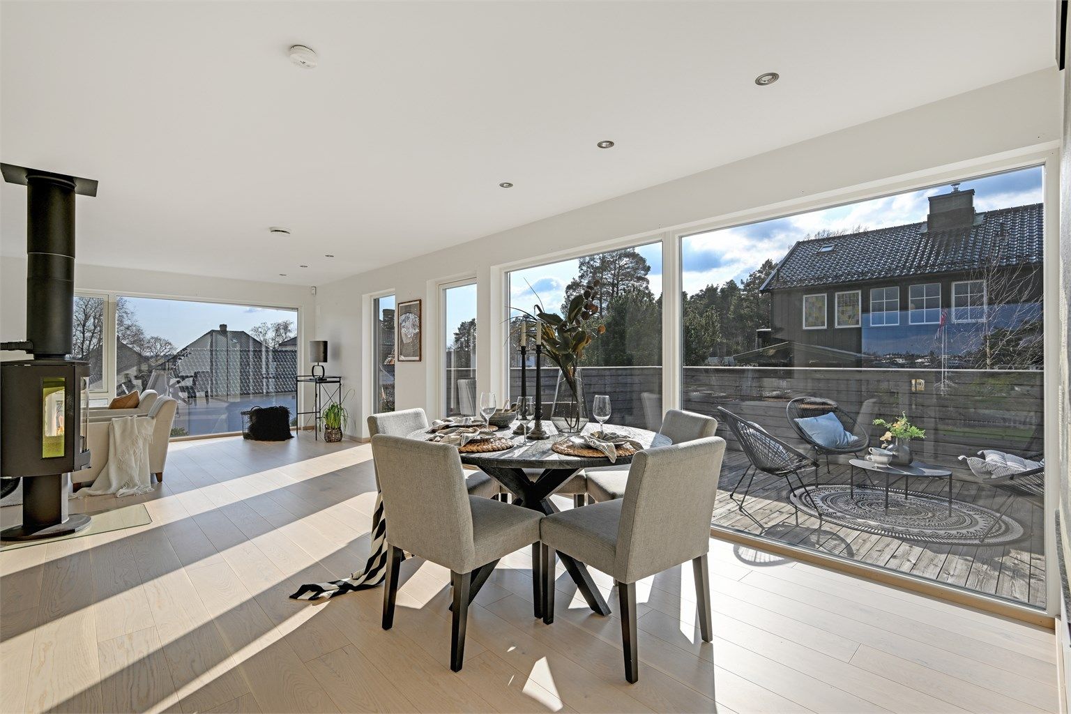 Den åpne planløsningen forener stue, spisestue og kjøkken, og bades i lys fra store vindusflater og glassdør mot balkongen.