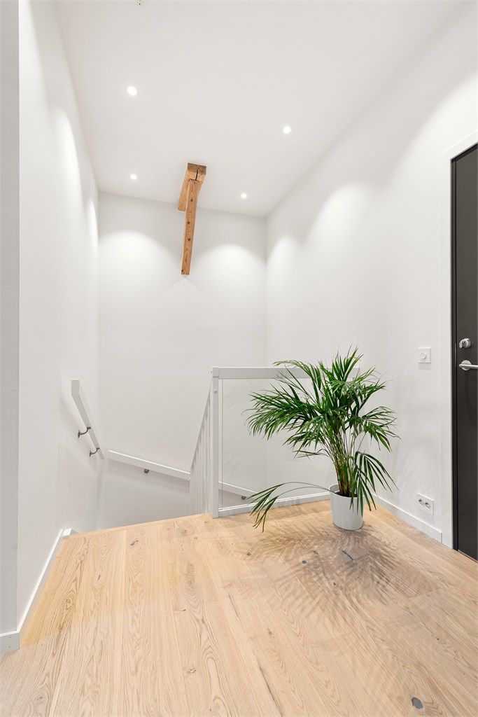Hallen på loftet har downlights i taket og gir adkomst til etasjens øvrige rom