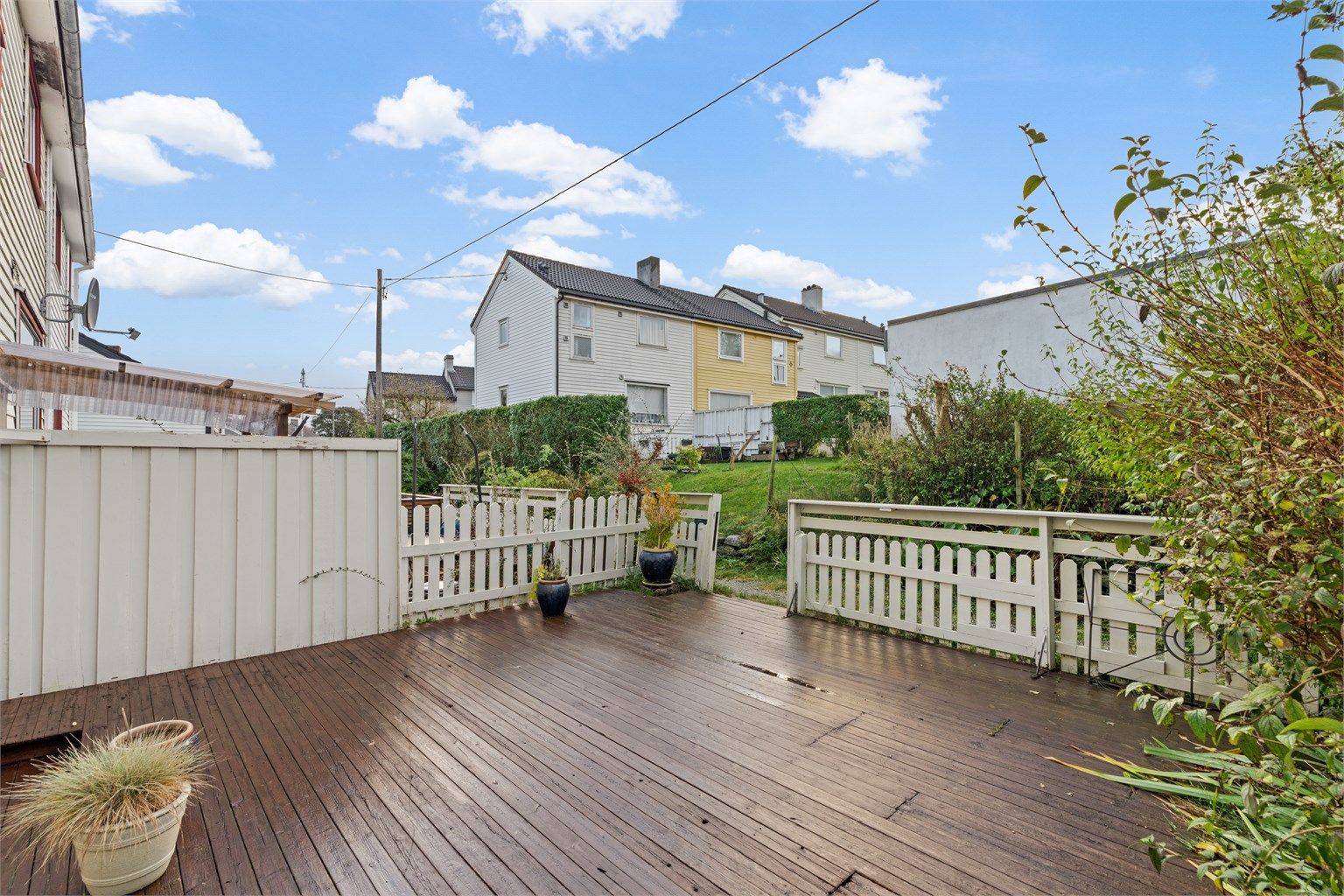 Romslig treterrasse på terreng med god plass til utemøbler og grill.