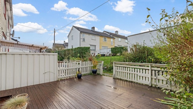 Romslig treterrasse på terreng med god plass til utemøbler og grill.