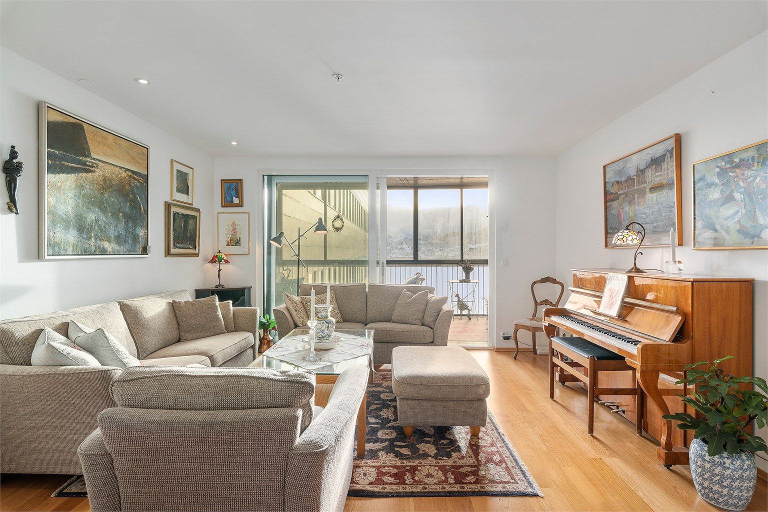 Stuedelen mot syd er trivelig innredet med lounge og øvrig møblement og dekor - herfra er det direkte utgang via skyvedør til en innglasset balkong på ca 12m²