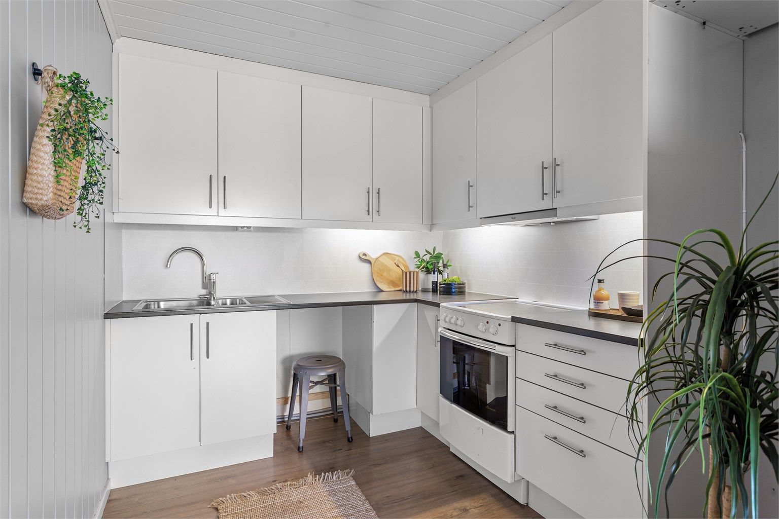 Kjøkken med innredning fra Norema med glatte fronter og benkeplate med laminert overflate og nedfelt kjøkkenvask