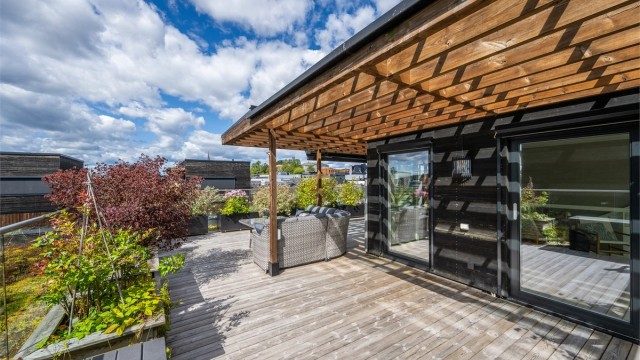 Her er det en nydelig pergola som legger til rette for din egen lille oase på byens tak.