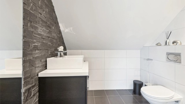 Moderne servantinnredning og vegghengt toalett.
