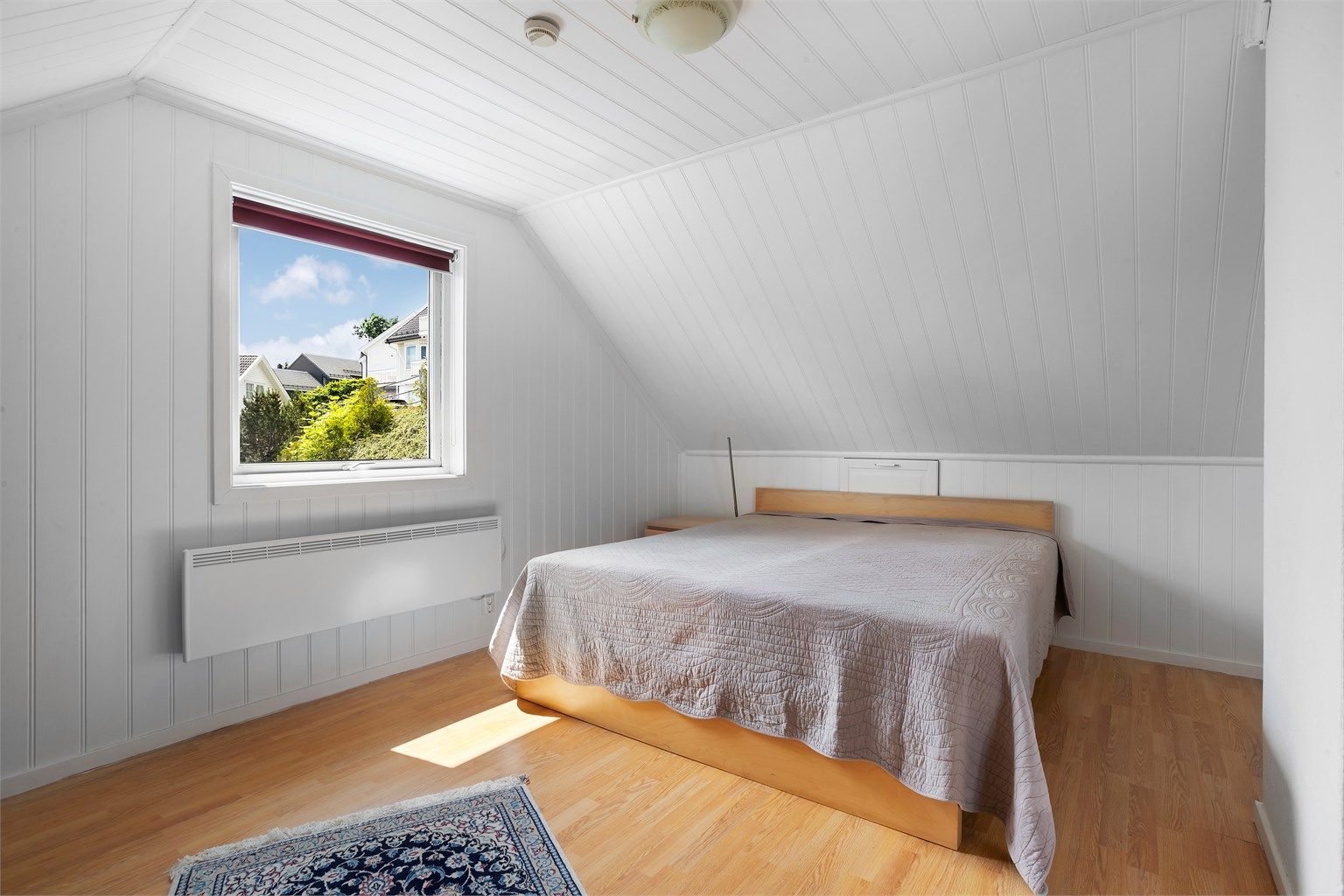 Soverom med plass til dobbeltseng og oppbevaringsmøbler.