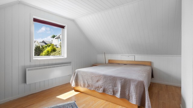 Soverom med plass til dobbeltseng og oppbevaringsmøbler.