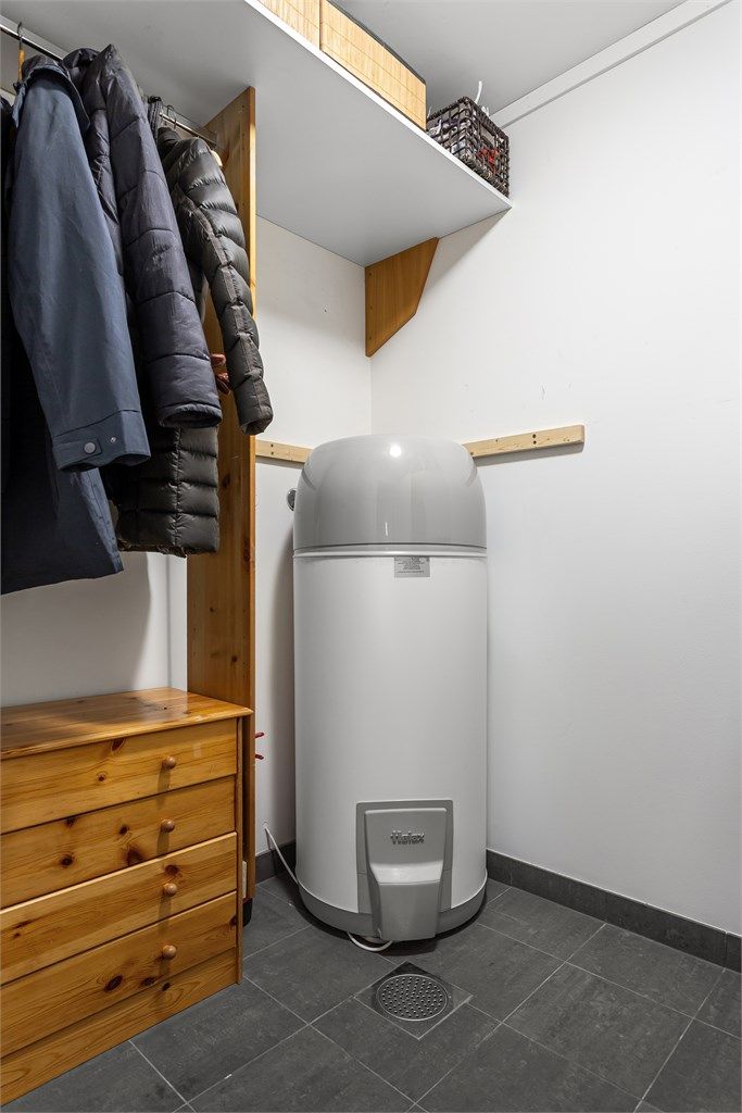 Teknisk rom med flislagt gulv med sluk. Plass til oppbevaring.