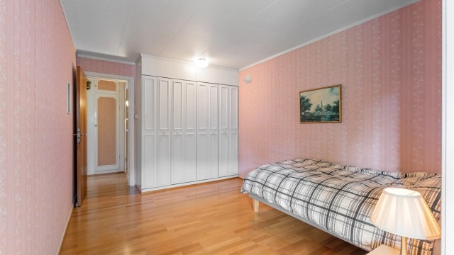 Ett av tre soverom i første etasje, utstyrt med garderobeskap.