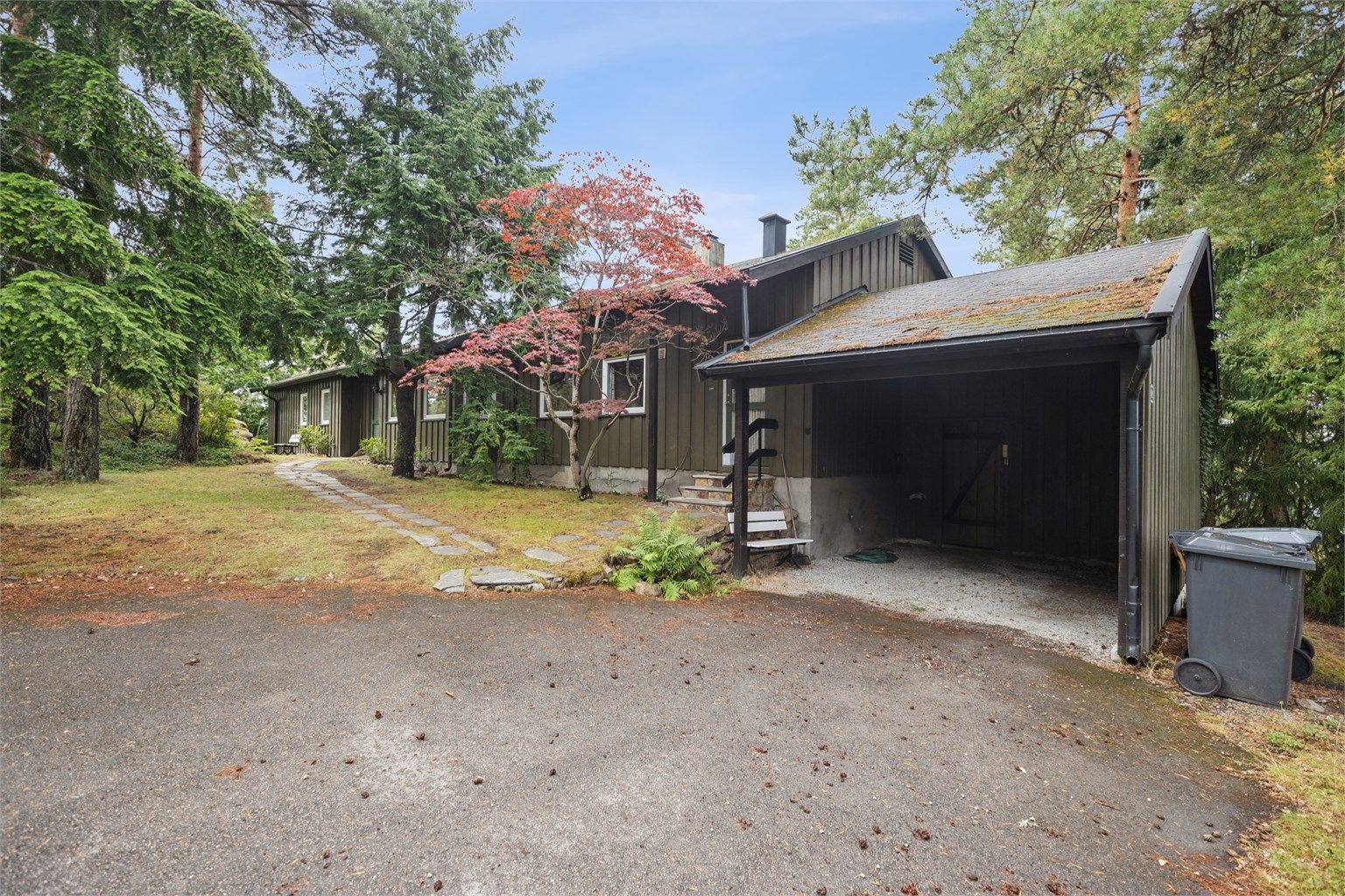 Tilbaketrukket og høytliggende – med skogen som nærmeste nabo. Parkering i garasje, samt biloppstillingsplasser på gårdsplassen.