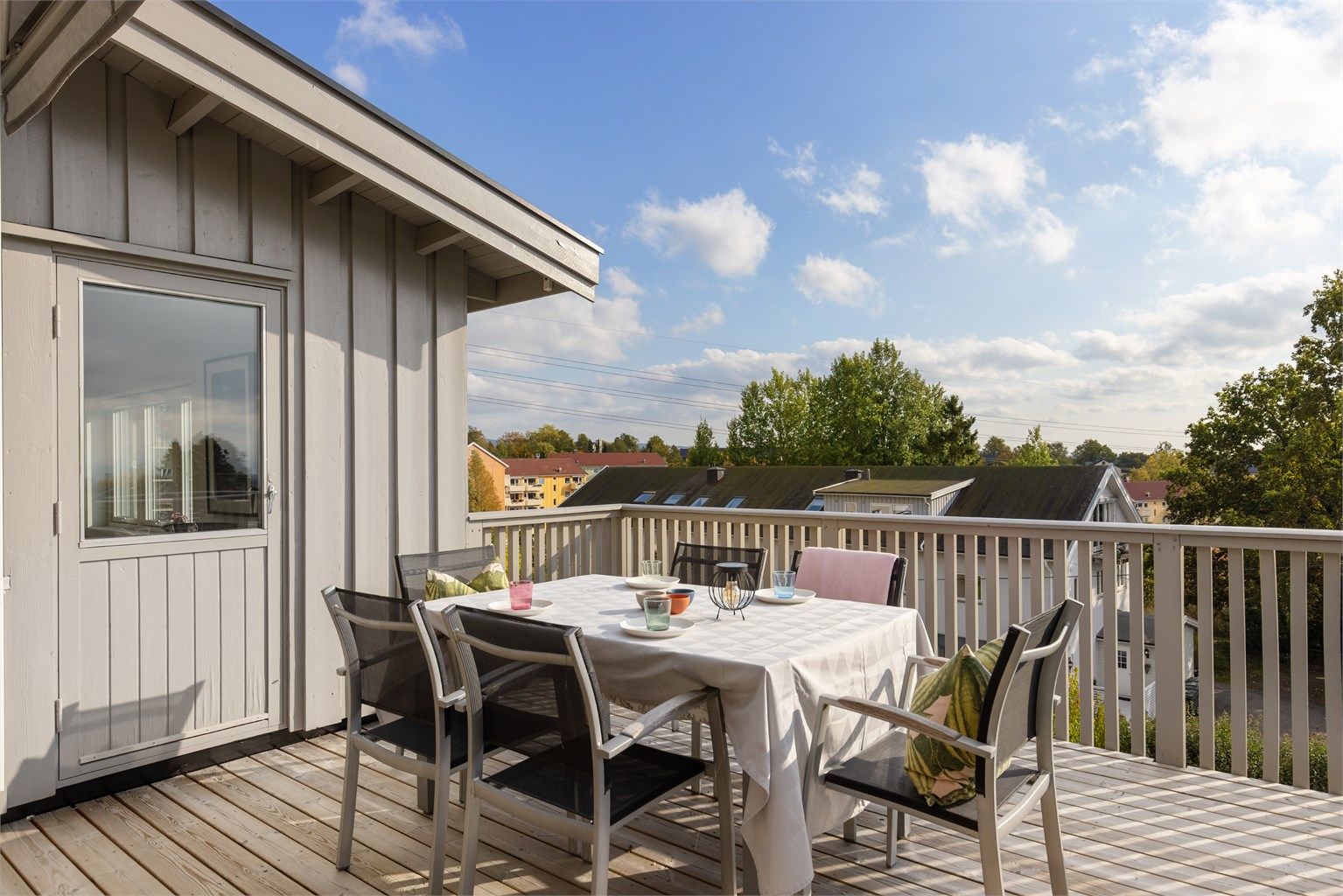 Balkongen har dekke av terrassebord og god plass til utendørs spisebord.
