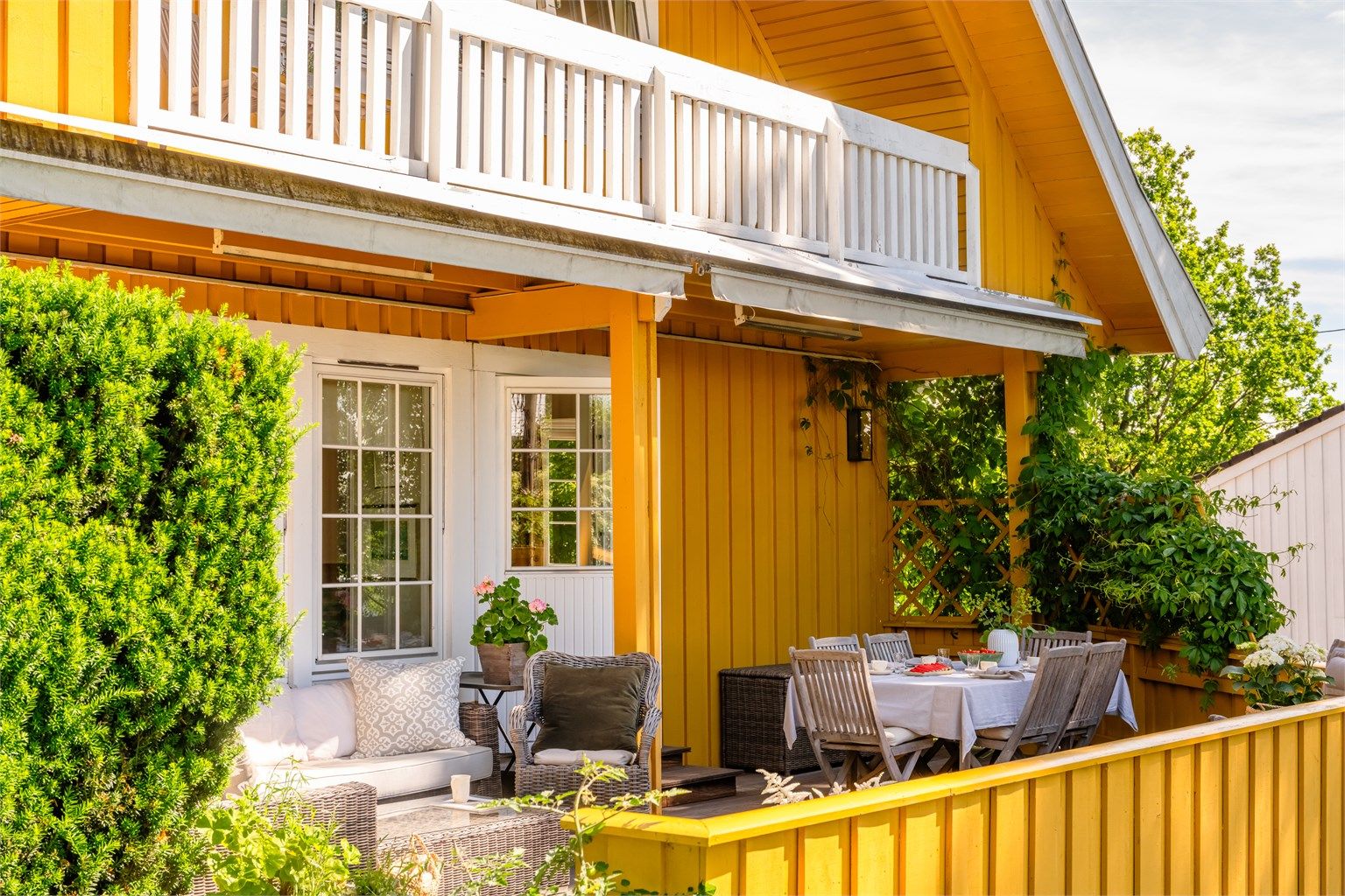Den romslige terrassen på 31 kvm er belagt med terrassebord og omkranset av et klassisk rekkverk i tre.