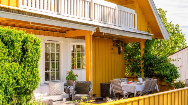 Den romslige terrassen på 31 kvm er belagt med terrassebord og omkranset av et klassisk rekkverk i tre.
