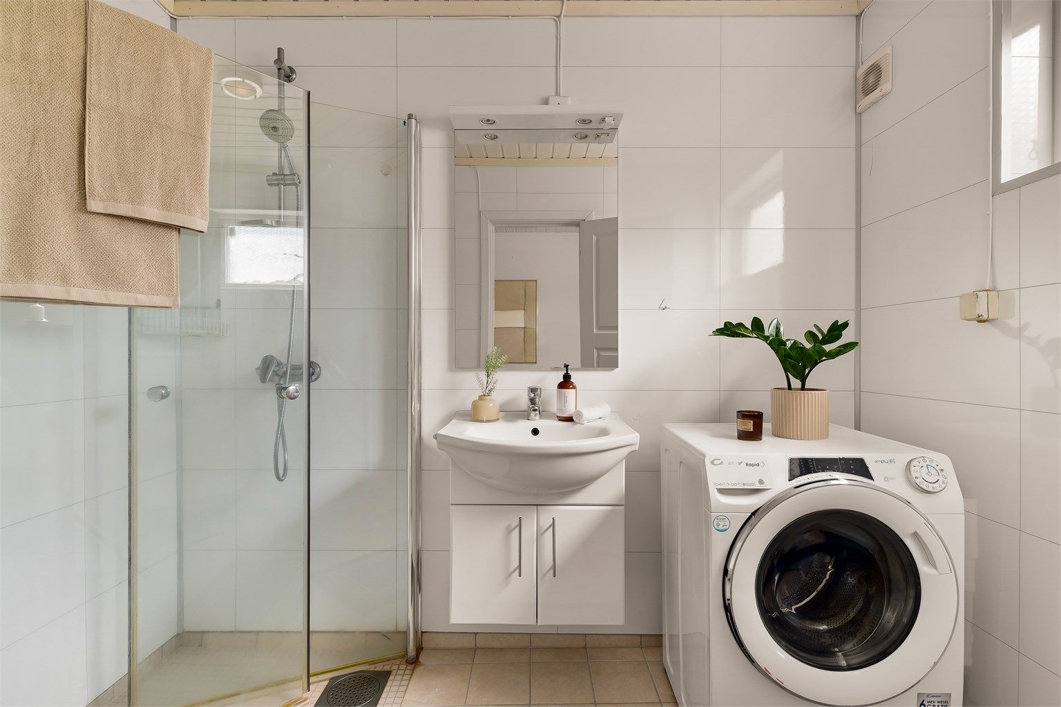 Innbydende bad med flislagt gulv og fulvvarme. Veggene er utført med våtromsplater, og badet har dusjhjørne med dusjvegger samt opplegg for vaskemaskin.