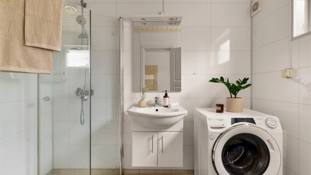 Innbydende bad med flislagt gulv og fulvvarme. Veggene er utført med våtromsplater, og badet har dusjhjørne med dusjvegger samt opplegg for vaskemaskin.