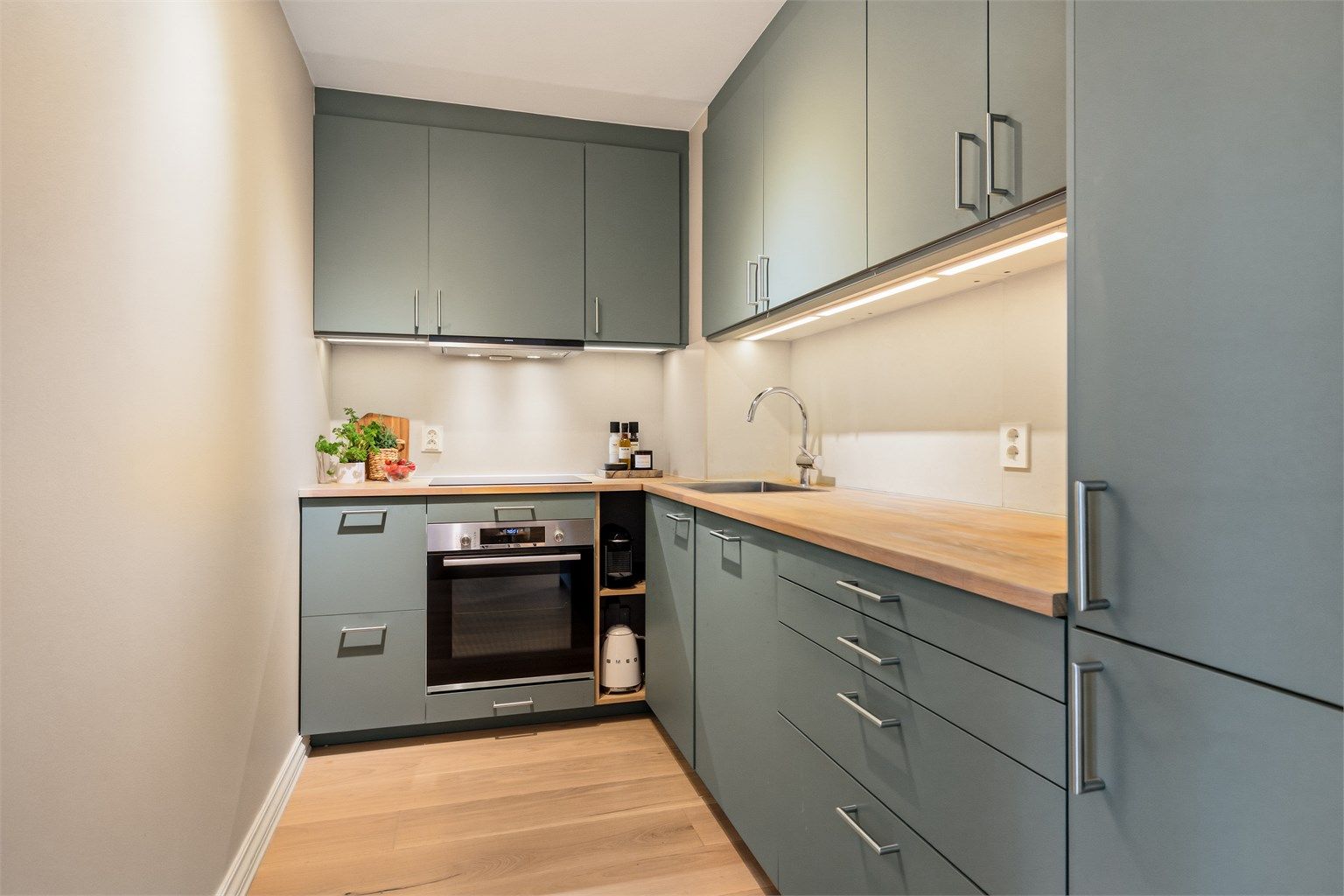 Moderne kjøkken fra 2020 med slette fronter, heltre benkeplate og rikelig med skap- og benkeplass. Foto: Trond Walsø / Walso Work