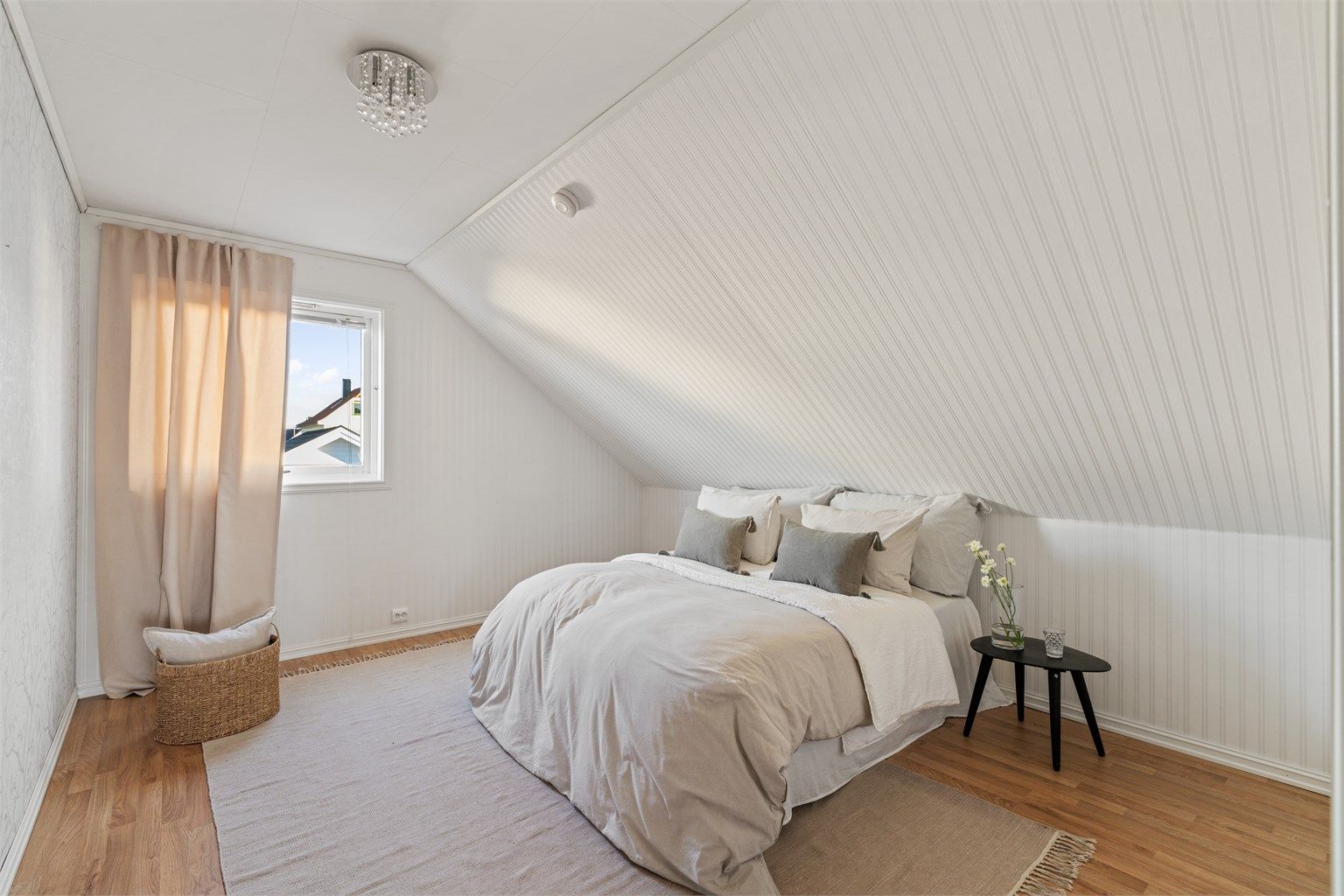 Soverom nummer to har hvitmalt panel på skråveggen og plass til dobbeltseng.