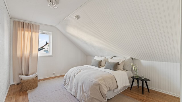 Soverom nummer to har hvitmalt panel på skråveggen og plass til dobbeltseng.