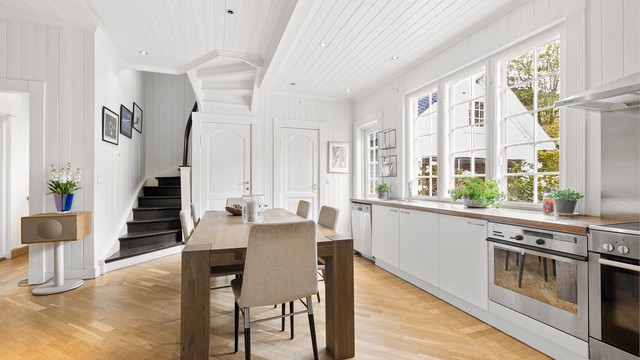 Kjøkkenet har parkett på gulv, panel på vegger og en praktisk innredning med glatte fronter.