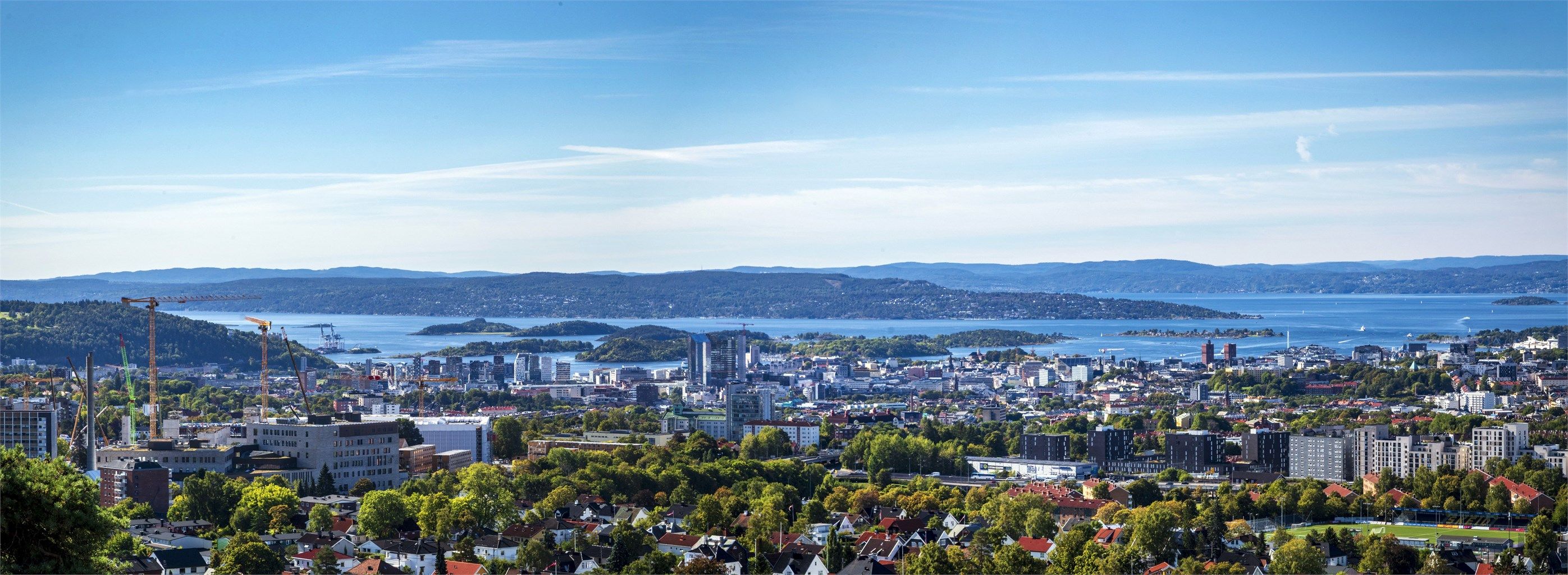 Vidstrakt utsikt over Oslofjorden, øyene og bykjernen.