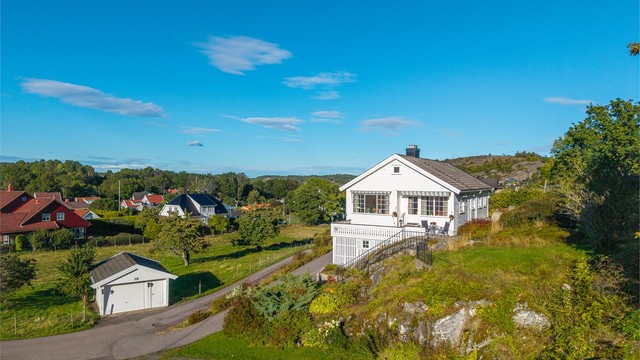 Boligen ligger skjermet til i terrenget med hage og utsikt mot nærområdet.