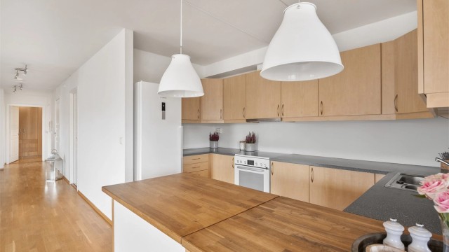 Kjøkkenøyen skaper en praktisk og sosial overgang mot spiseplassen.