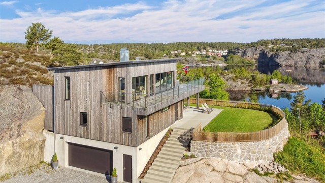 Boligen er arkitektonisk tilpasset terrenget, med integrert garasje i underetasjen. Fotograf: Sønnavind