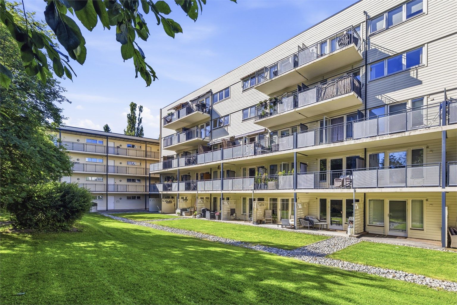 Felles tomt opparbeidet med blant annet asfalterte veier, belegningsstein, biloppstillingsplass, sittegrupper, plenarealer og andre forskjellige beplantninger