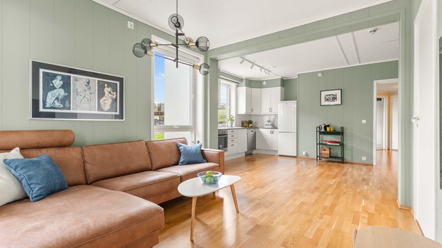 Stuen og kjøkkenet danner et stort, åpent allrom med gjennomgående parkettgulv og en takhøyde på opptil 2,60 meter.