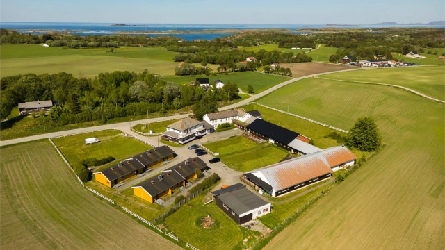 Omkranset av åkrer og skogteiger er det godt med plass rundt hele anlegget, og området betegnes av et åpent, flott og frodig kystlandskap.