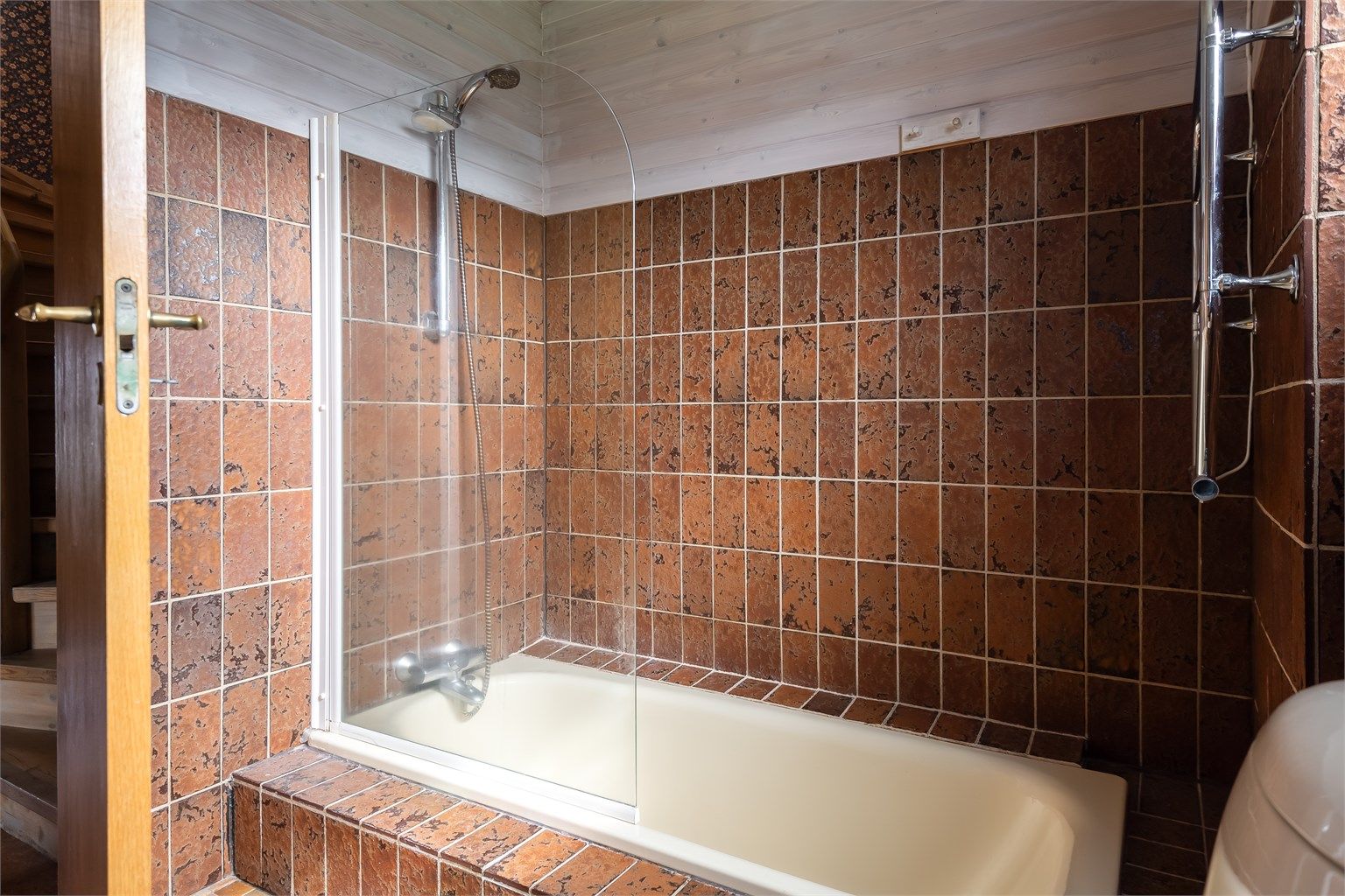 Videre er badet utstyrt med servantskap med overskap og speil med lys, toalett og badekar med vegghengt dusjarmatur. 