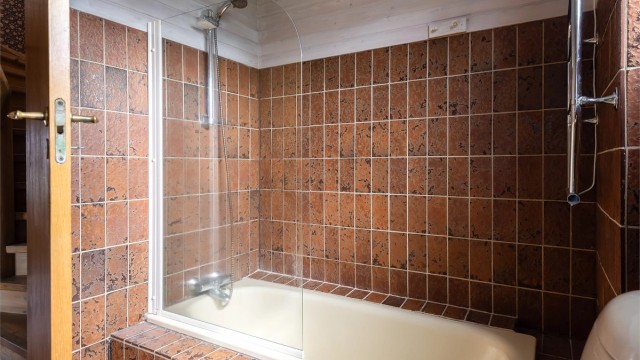 Videre er badet utstyrt med servantskap med overskap og speil med lys, toalett og badekar med vegghengt dusjarmatur.