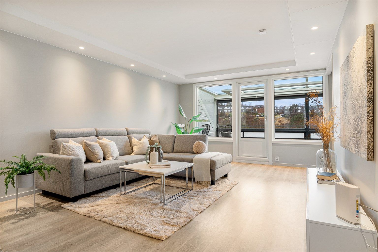 Stuen er nylig malt i en lun, beige farge. Spotter i himling gir en fin lyssetting. 