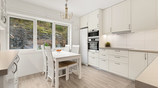 Stort og tidløst IKEA-kjøkken med profilerte fronter og laminat benkeplate.